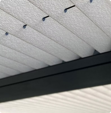 Weiße Deckenpaneele mit schmalen Lüftungsschlitzen in einem modernen Design.