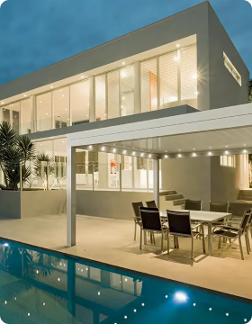 Modernes Haus mit Glasfront und Pool bei Abendbeleuchtung.