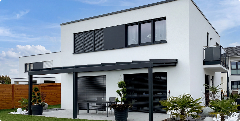 Modernes zweistöckiges Haus mit Terrasse und Garten.