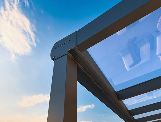 Moderne Metallpergola mit Glasdach vor blauem Himmel.