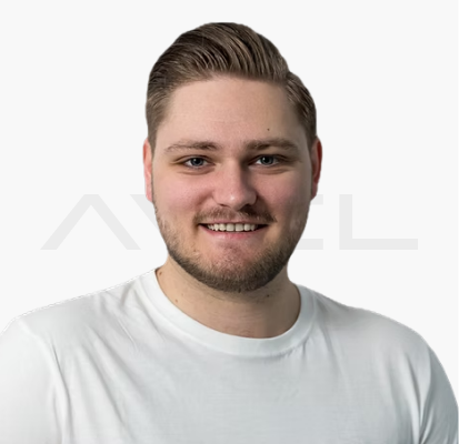 Mann im weißen T-Shirt steht vor neutralem Hintergrund und lächelt.