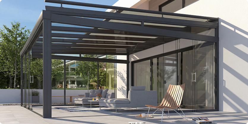Moderne Glasveranda mit stilvollen Möbeln und Blick auf einen Garten.