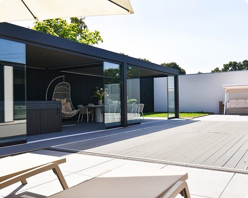 Moderne Terrasse mit Glasüberdachung, Lounge-Möbeln und einem Sonnenschirm.